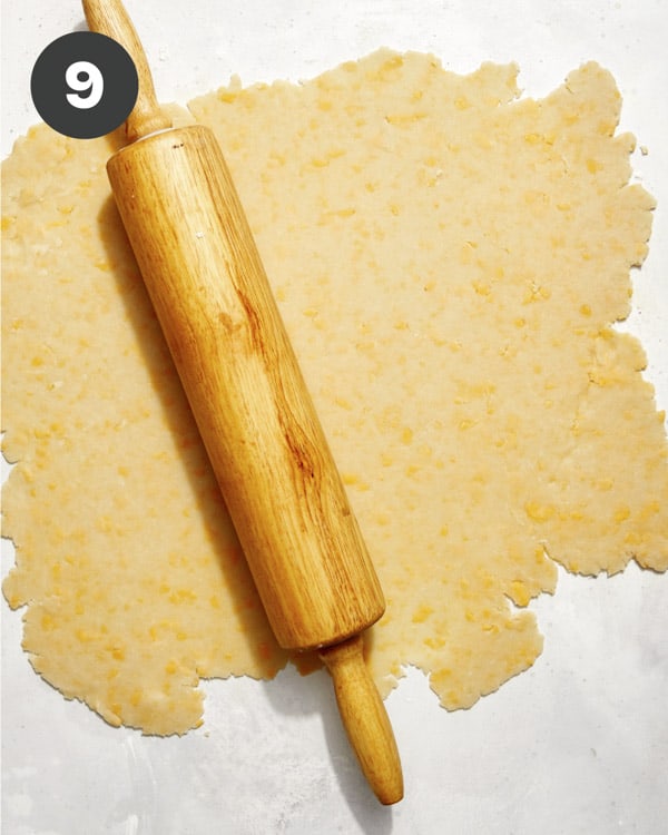 A cheddar crust rolled out on a surface.