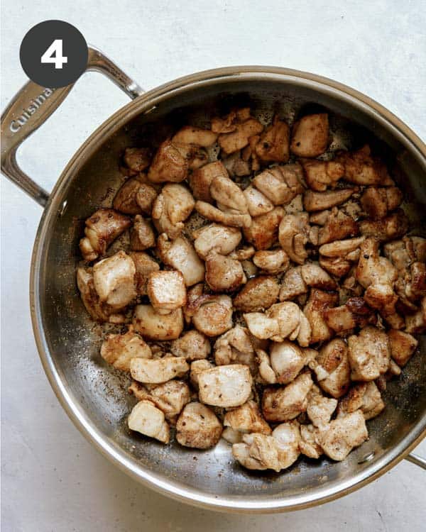 Chicken cooking in a skillet to make butter chicken.
