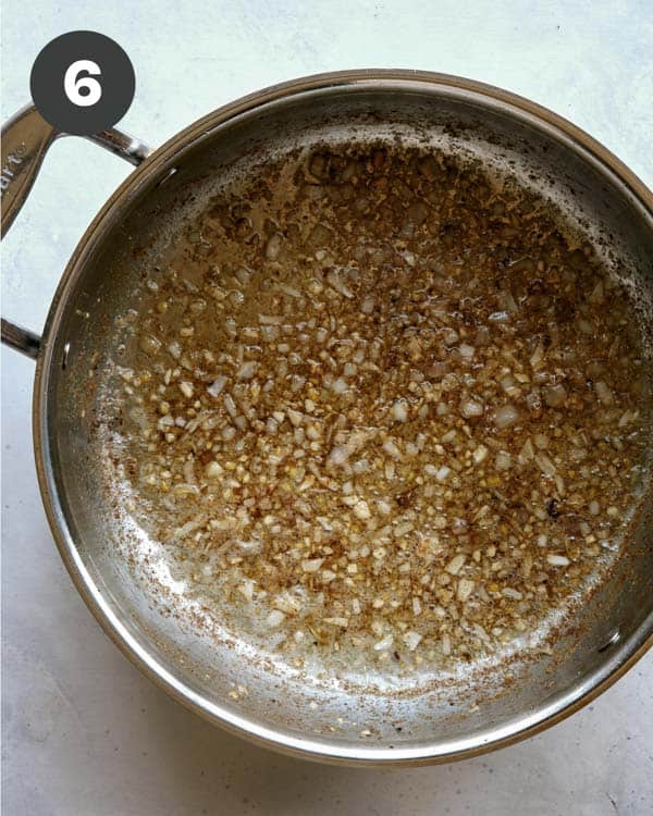 Skillet with melted butter and garlic to make butter chicken.
