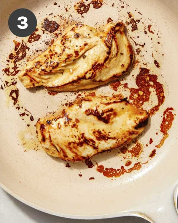 Chicken cooking in a skillet.