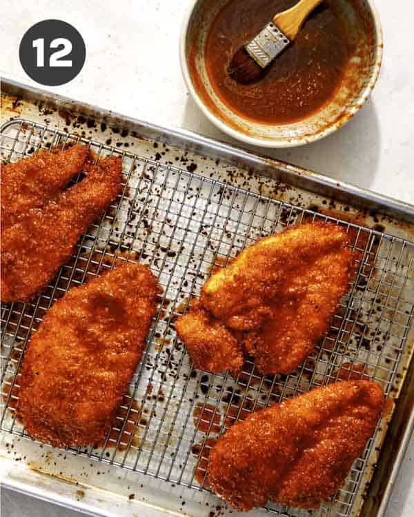 Hot honey chicken sandwiches being brushed with spicy honey.