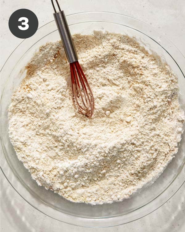 Flour mixture in a shallow baking dish to make hot honey chicken sandwiches.