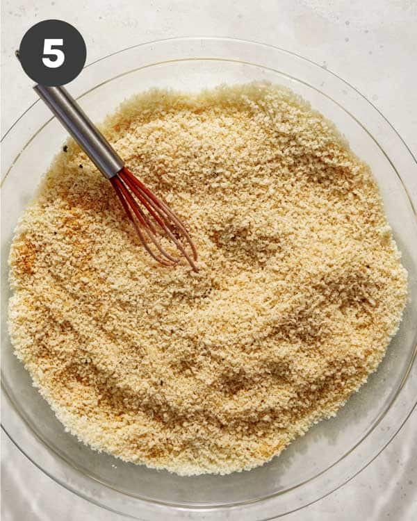 Panko and seasoning in a shallow baking dish to make a breakfast sandwich.