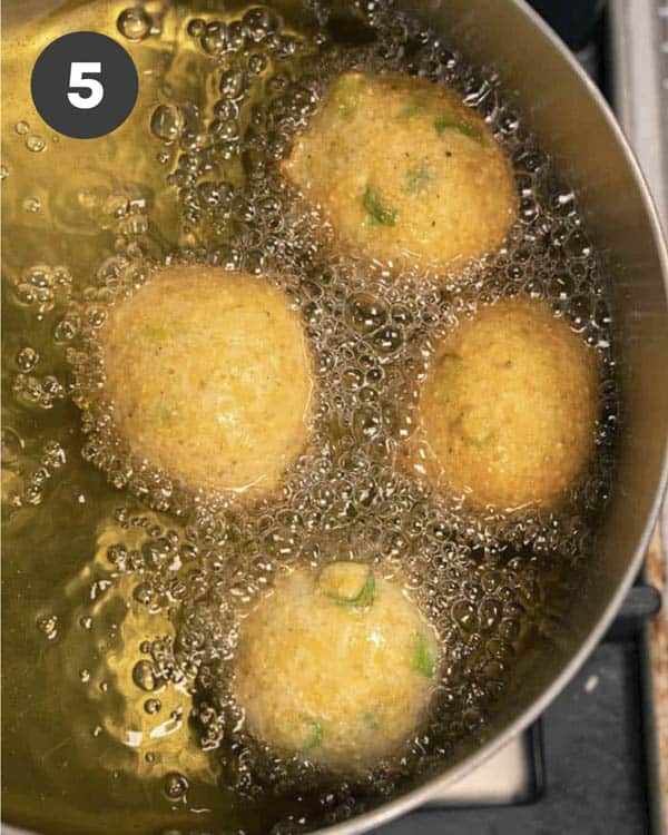 Hush Puppies frying in a pot of oil.
