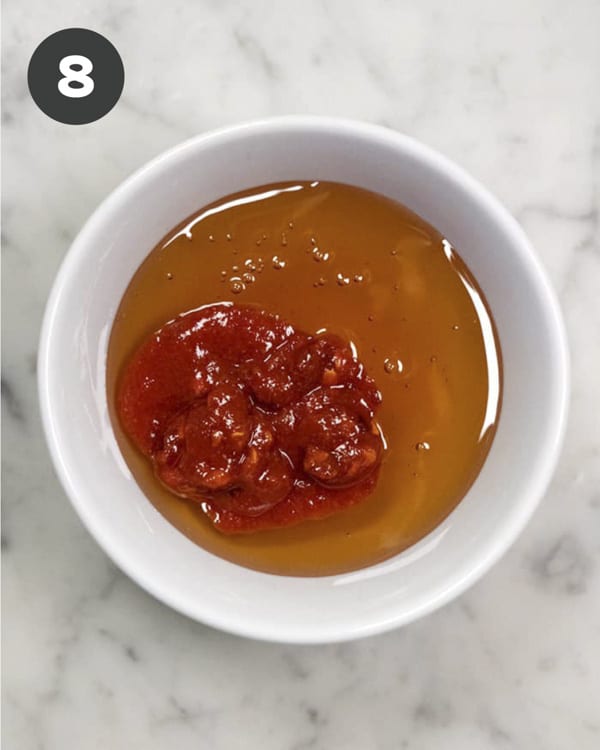 Spicy honey drizzle ingredients in a bowl ready to be mixed.