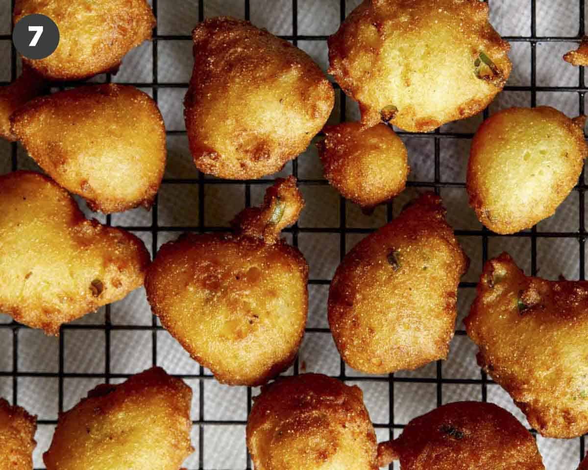 A close up of hush puppies on a wire rack.