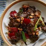 Kung pao beef in two bowls over rice.
