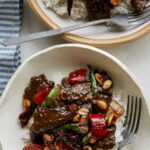 Kung pao beef in two bowls over rice.