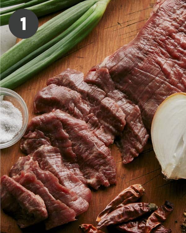 Flank steak being sliced for kung pao beef.