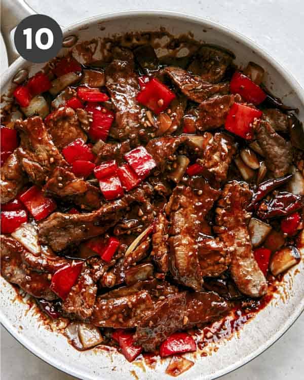 Kung pao beef cooking in a skillet.