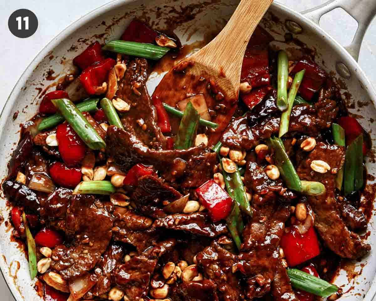 Kung pao beef cooking in a skillet.