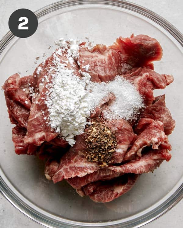 Kung pao beef flank steak in a bowl with seasonings.
