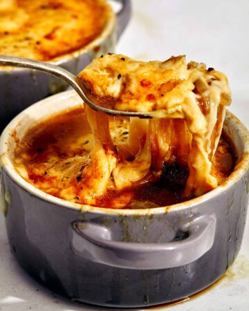 French onion soup with a spoon in it.