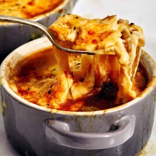 French onion soup with a spoon in it.