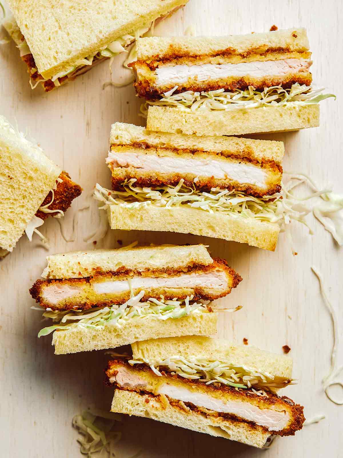 Kiaulienos katsu sumuštiniai supjaustyti per pusę.
