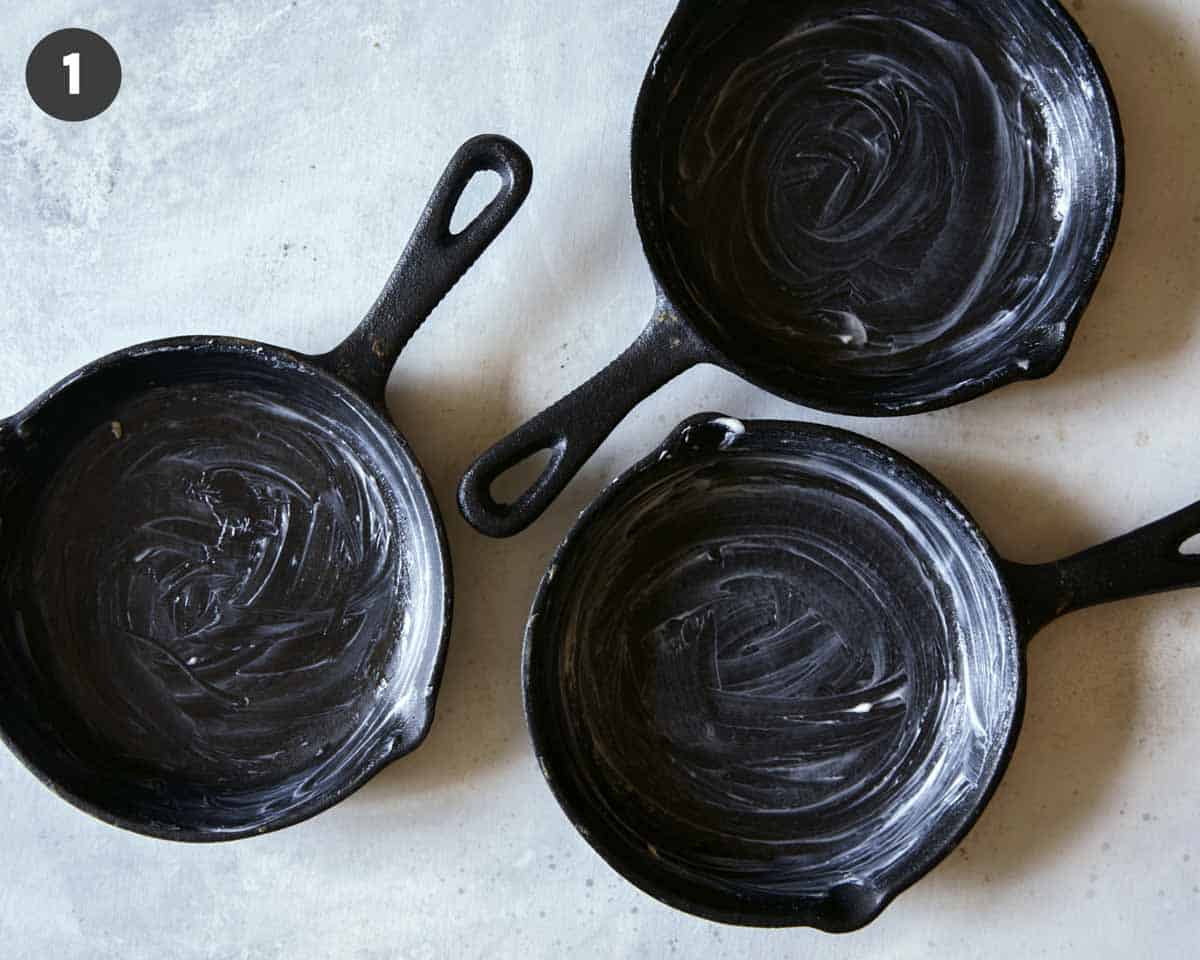 Buttered cast iron skillets to make apple crisps.