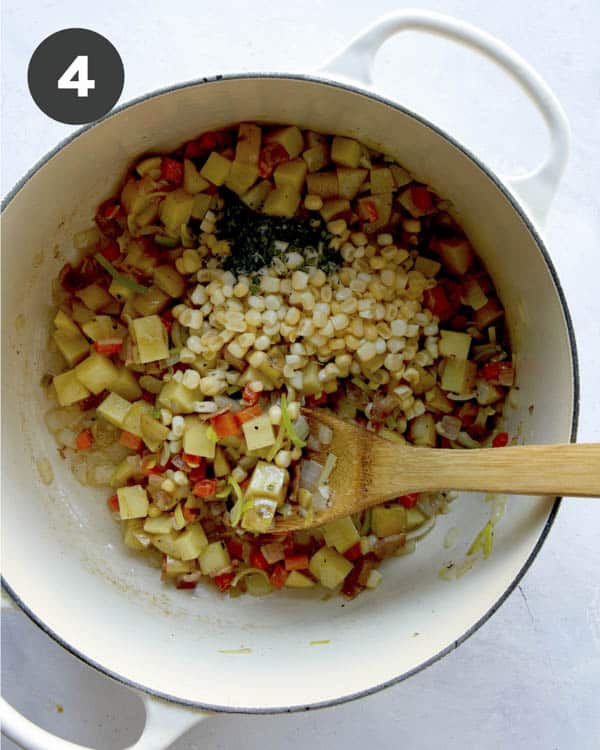 Clam chowder ingredients with corn and thyme added to a pot.