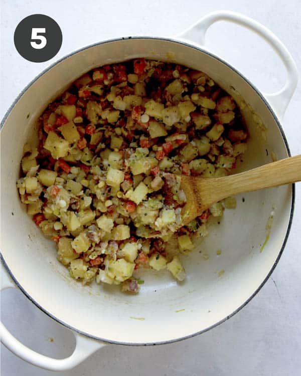 Cooking down the ingredients to make clam chowder in a pot.