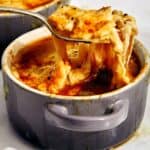 French onion soup recipe in a bowl with a spoon in it.