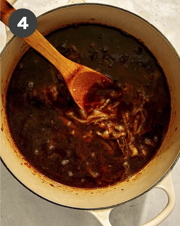 The base of french onion soup in a pot cooking. 