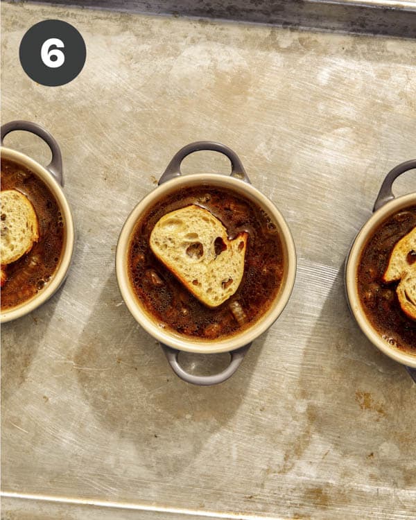 French onion soup with bread pieces on top.
