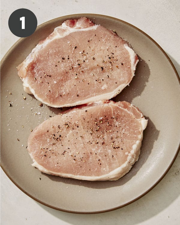 Seasoned pork chops on a plate. 