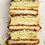 Stacked pork katsu sandwiches cut in half.