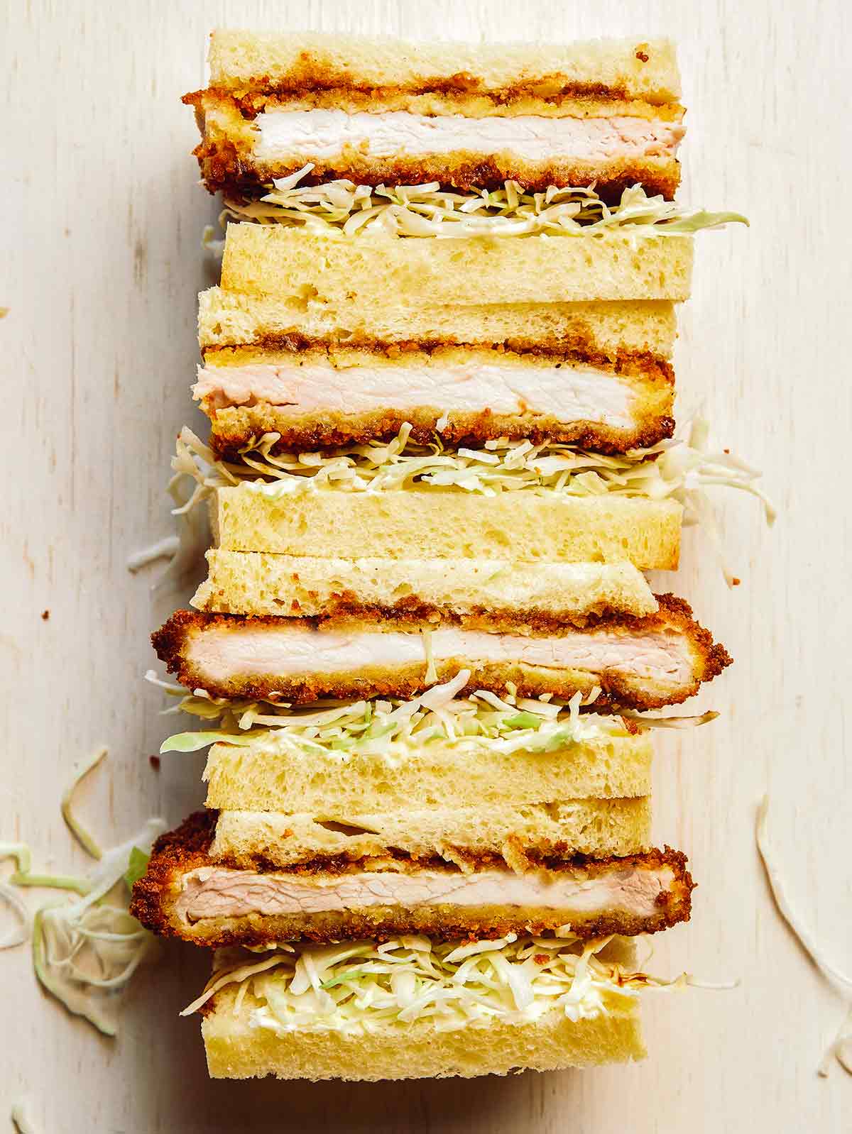 Sukrauti kiaulienos katsu sumuštiniai, supjaustyti per pusę.
