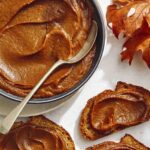 Pumpkin butter in a bowl with pieces of toast.