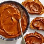 Pumpkin butter in a bowl with pieces of toast.