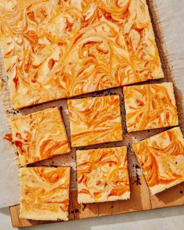 Pumpkin cheesecake bars on a board.