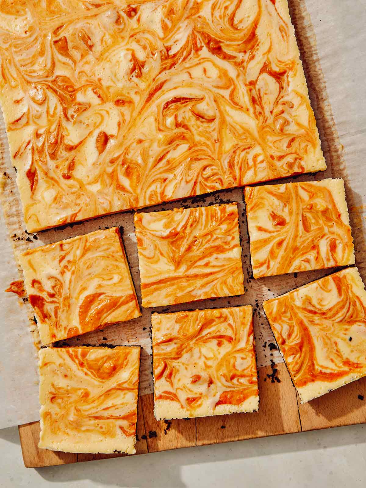 Pumpkin cheesecake bars on a board. 