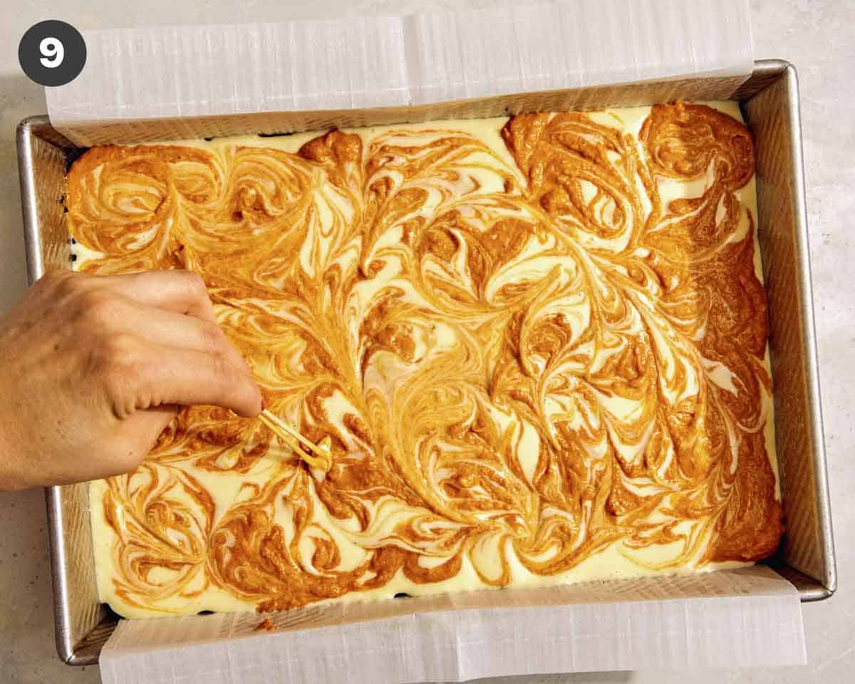 Marbled cheesecake bars being marbled. 
