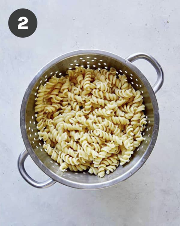 Cooked and drained fusilli pasta in a colander.