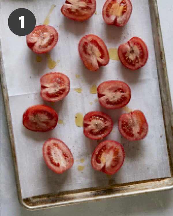 Tomatoes on a baking sheet about to be roasted to make tomato soup. 