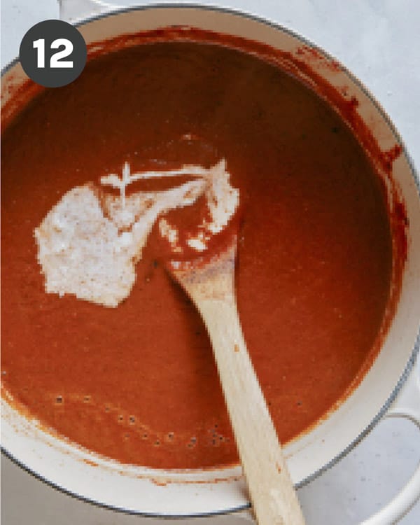 Heavy cream added into a stock pot full of tomato soup.