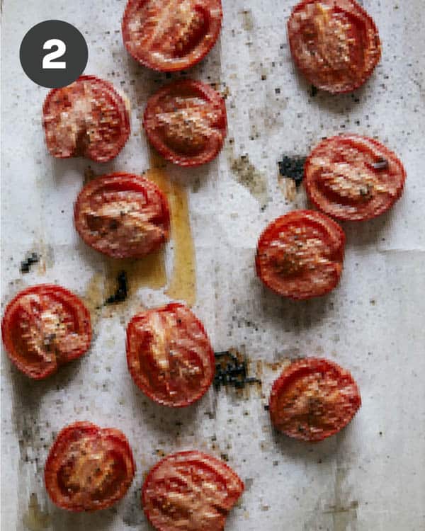 Roasted roma tomatoes on a baking sheet.
