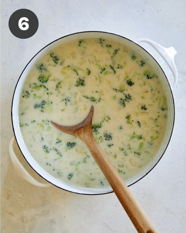 Milk added into a stock pot with broccoli cheddar soup.