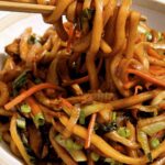 Yaki udon noodles in bowl being eaten.