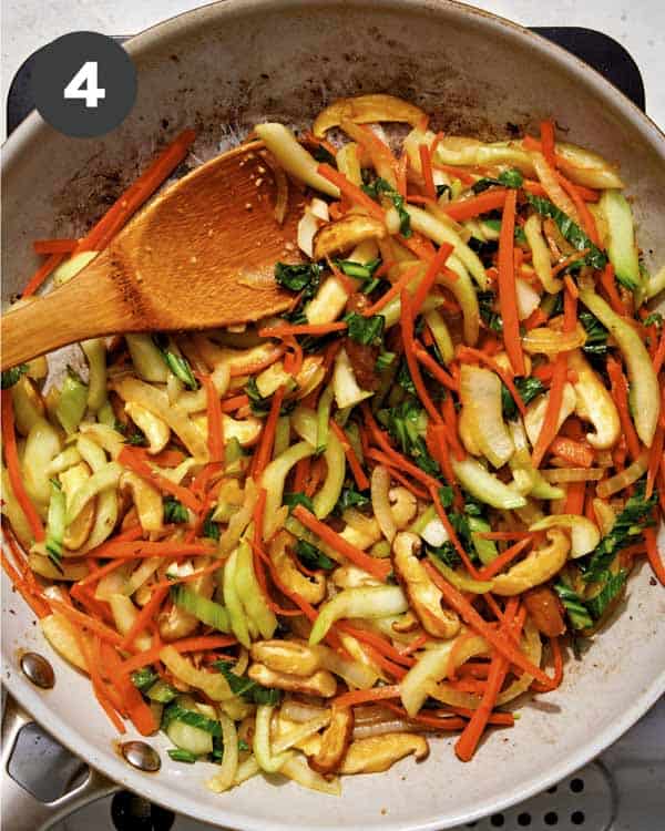 Vegetables cooking in a skillet to make yaki udon noodles.