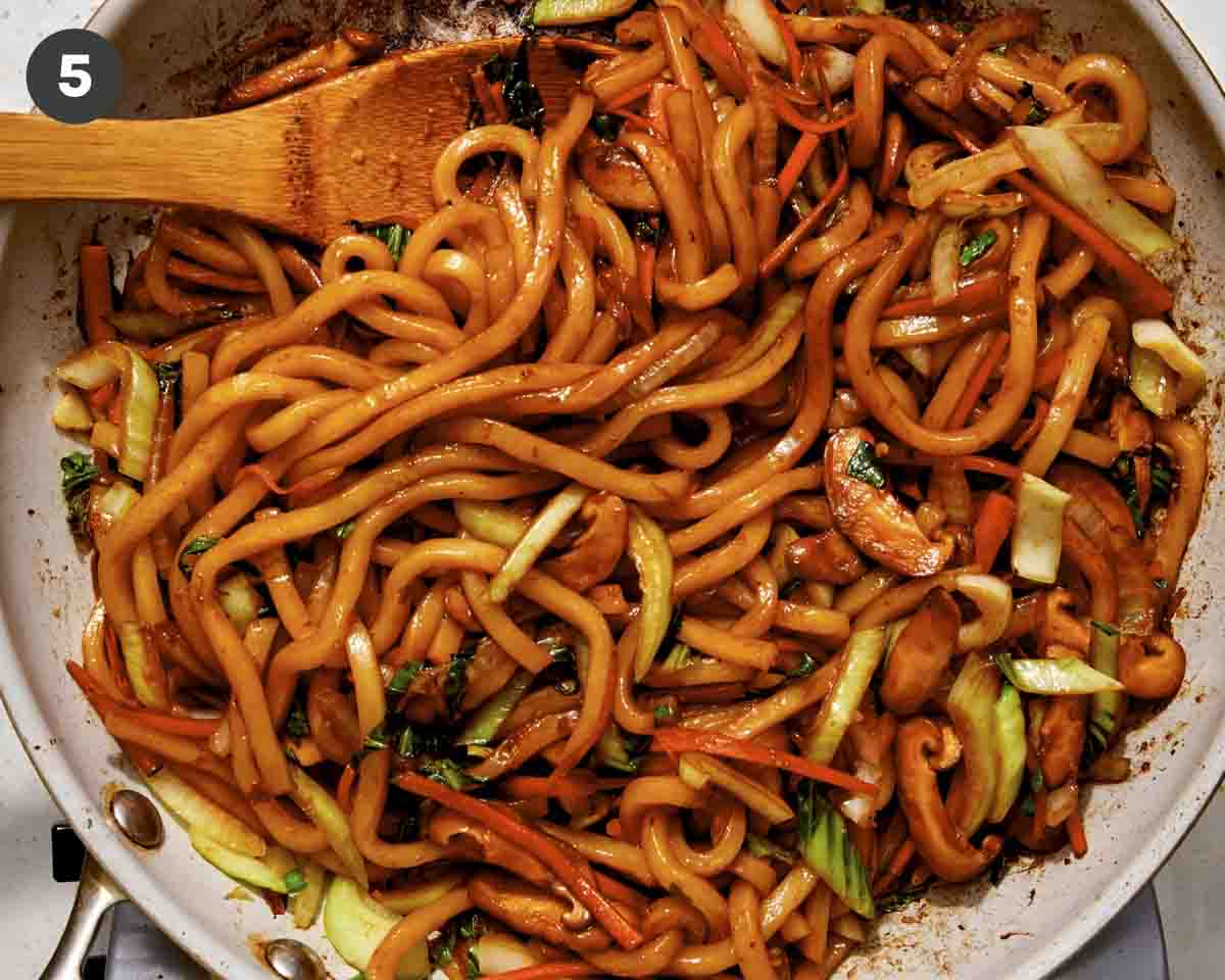 Yaki udon noodles cooking in a skillet.