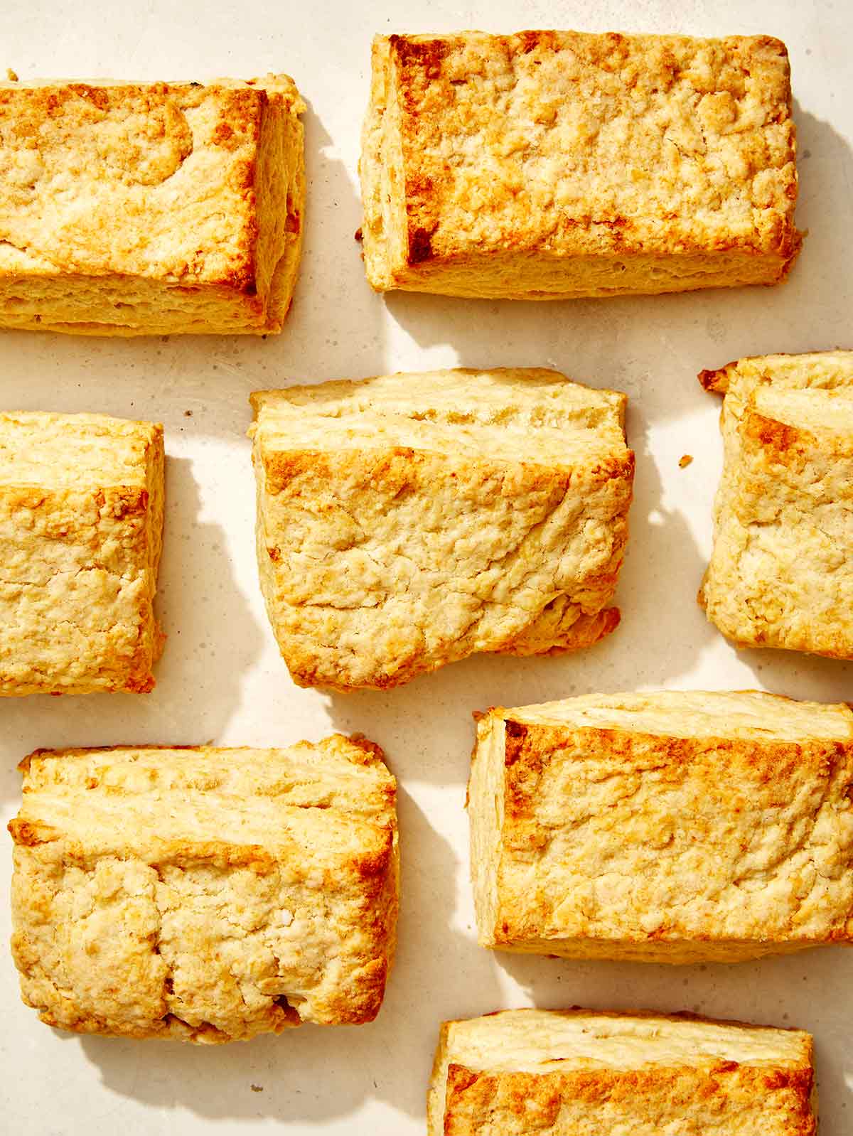 Buttermilk biscuits spread out on a surface. 