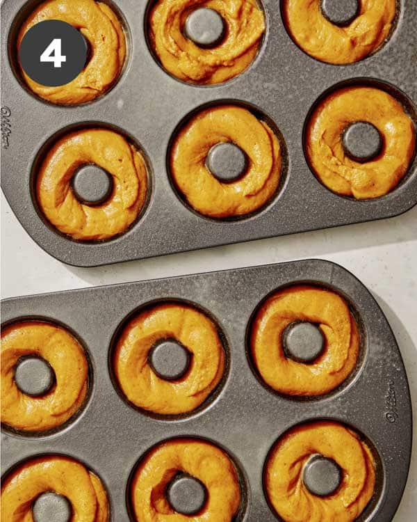 Pumpkin batter in donut trays ready to be baked.