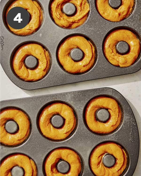 Pumpkin batter in donut trays ready to be baked. 