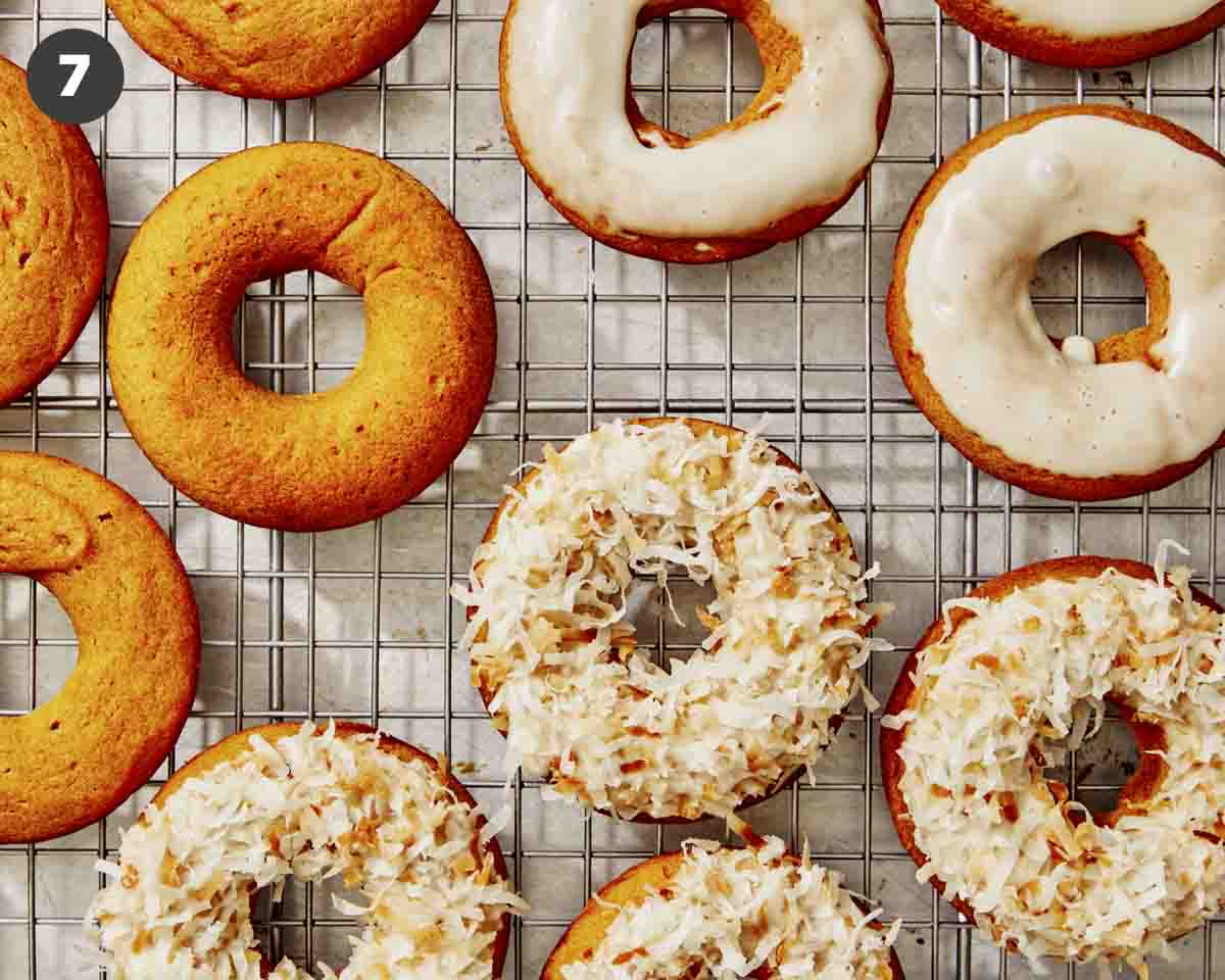 Pumpkin donuts being glazed with coconut.