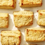 Buttermilk biscuits spread out on a surface.