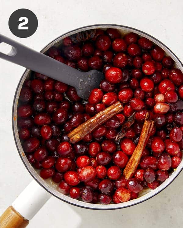 Cranberry sauce recipe simmering in a pot. 