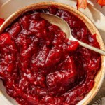 Cranberry sauce recipe in a bowl with spoon in it.