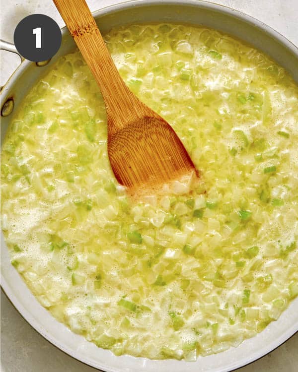 Onions and celery cooking in a skillet to make stuffing.