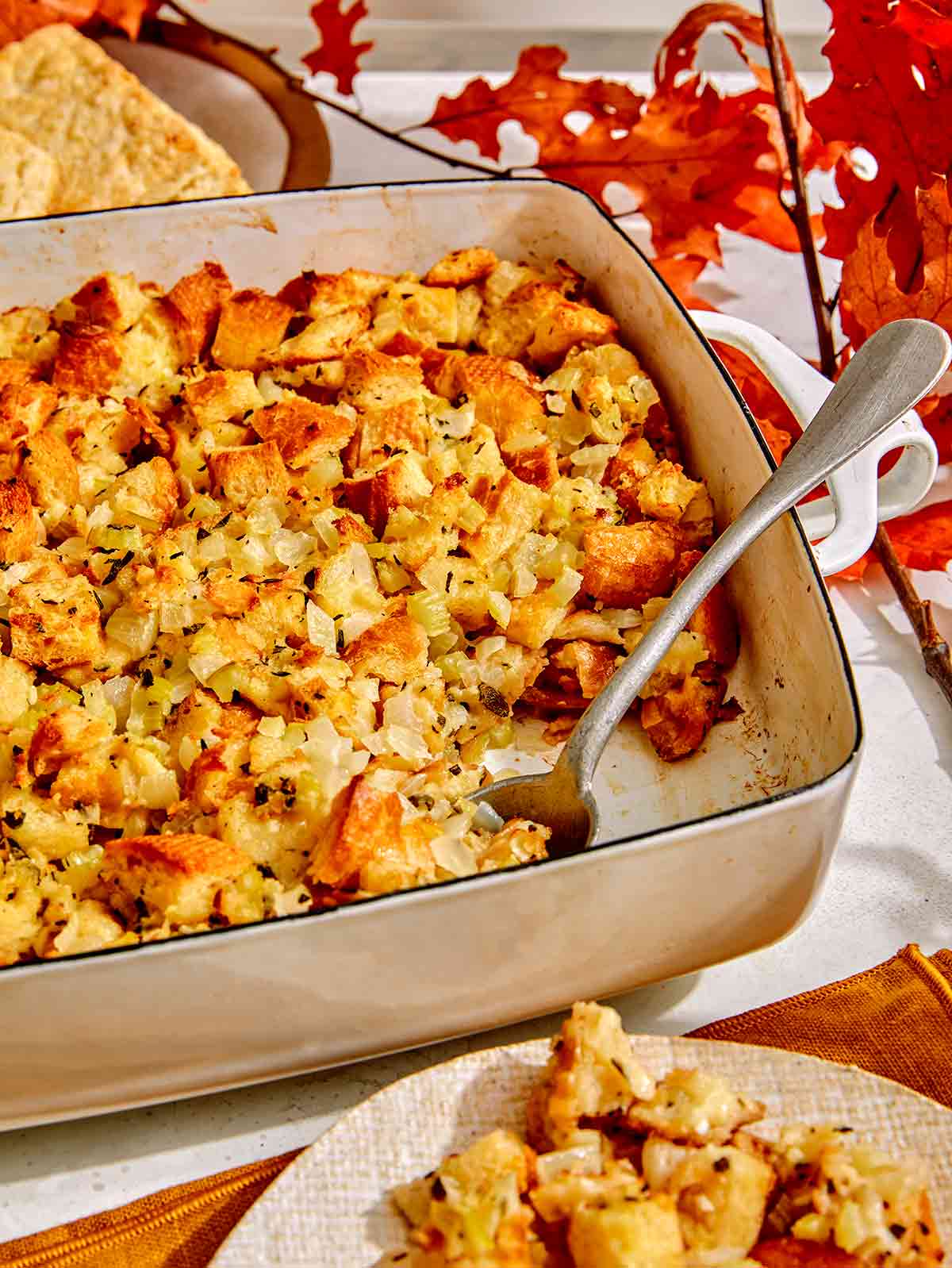 Stuffing in a baking dish with a spoon in it.
